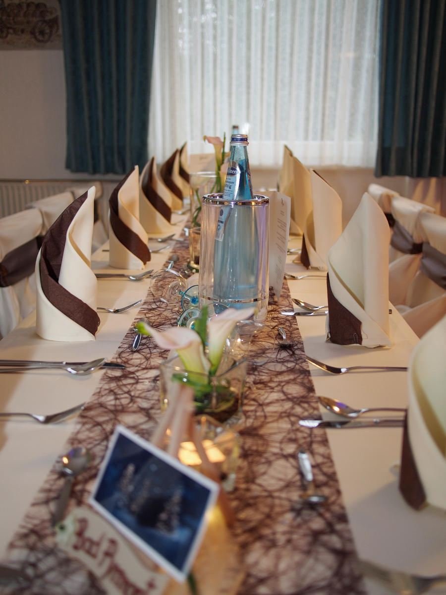 Lange festlich gedeckte Tafel mit Servietten und Dekoration