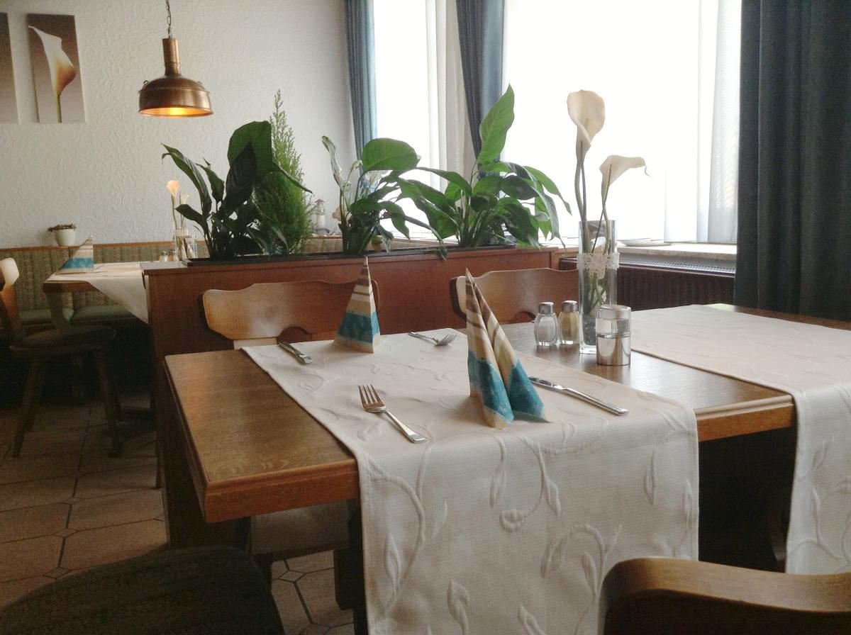 Gedeckter Tisch mit Blumendekoration in der Gaststube