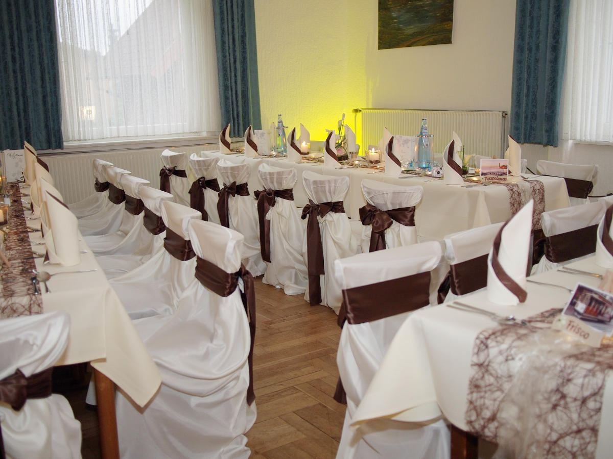 Festlich eingedeckter Saal mit Hussen auf den Stühlen